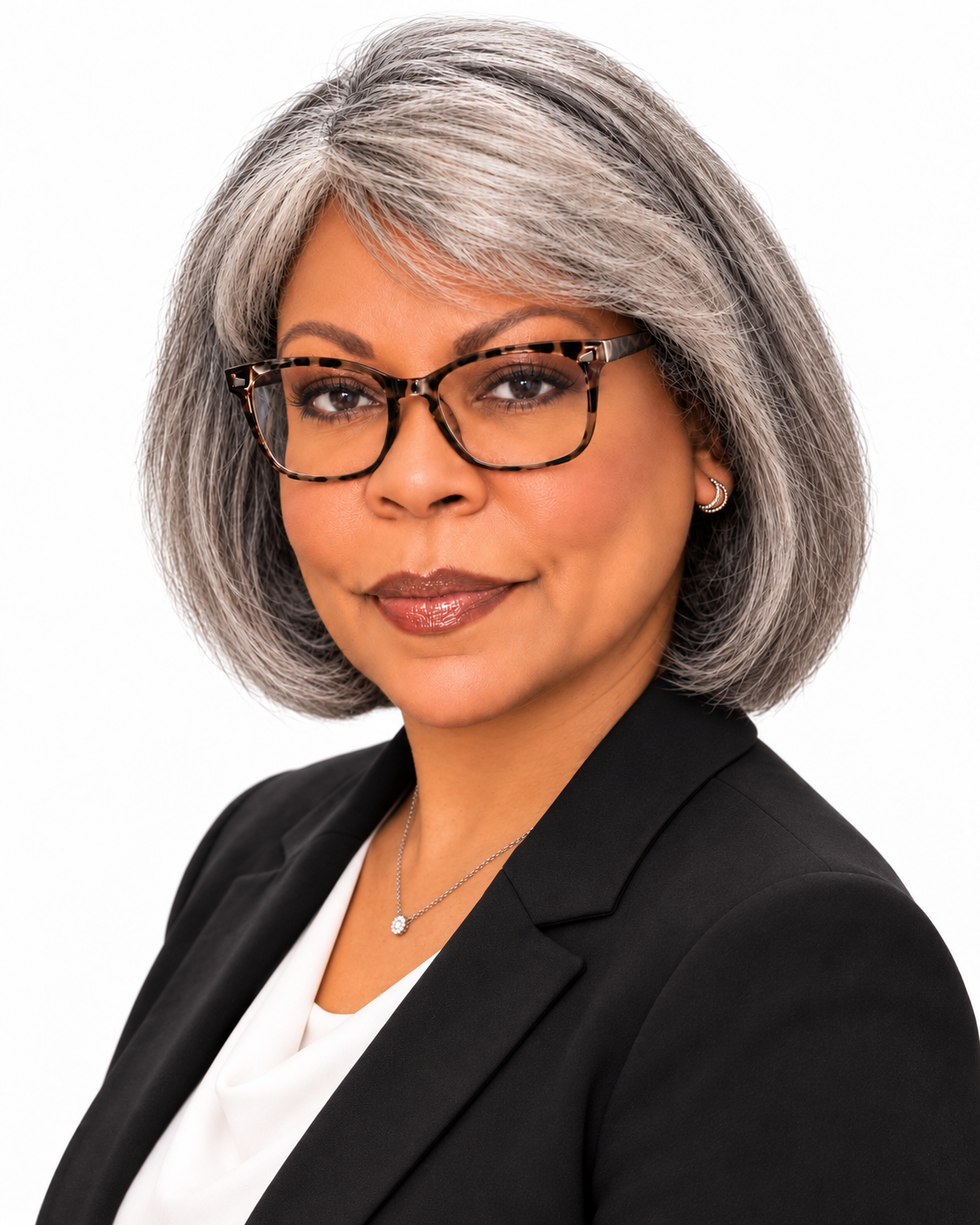 Janice R. Ani in a black blazer, with a silver bob hairstyle and glasses